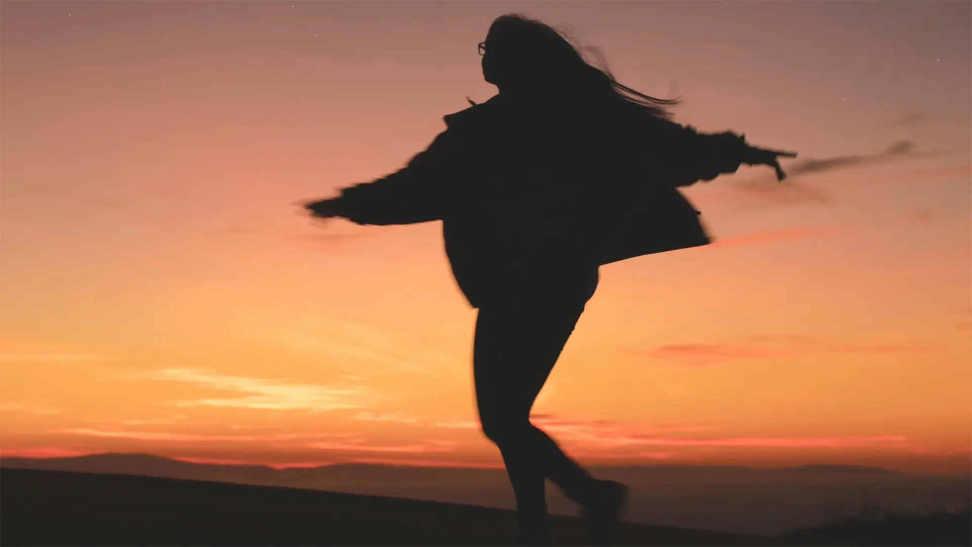 A photo of a figure dancing in the golden hour