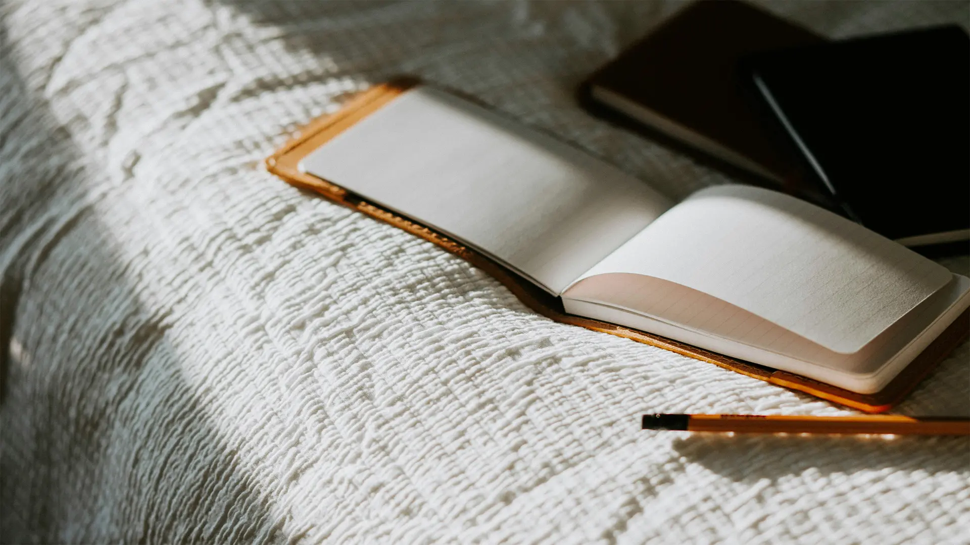 A photo of a notebook and a pencil.