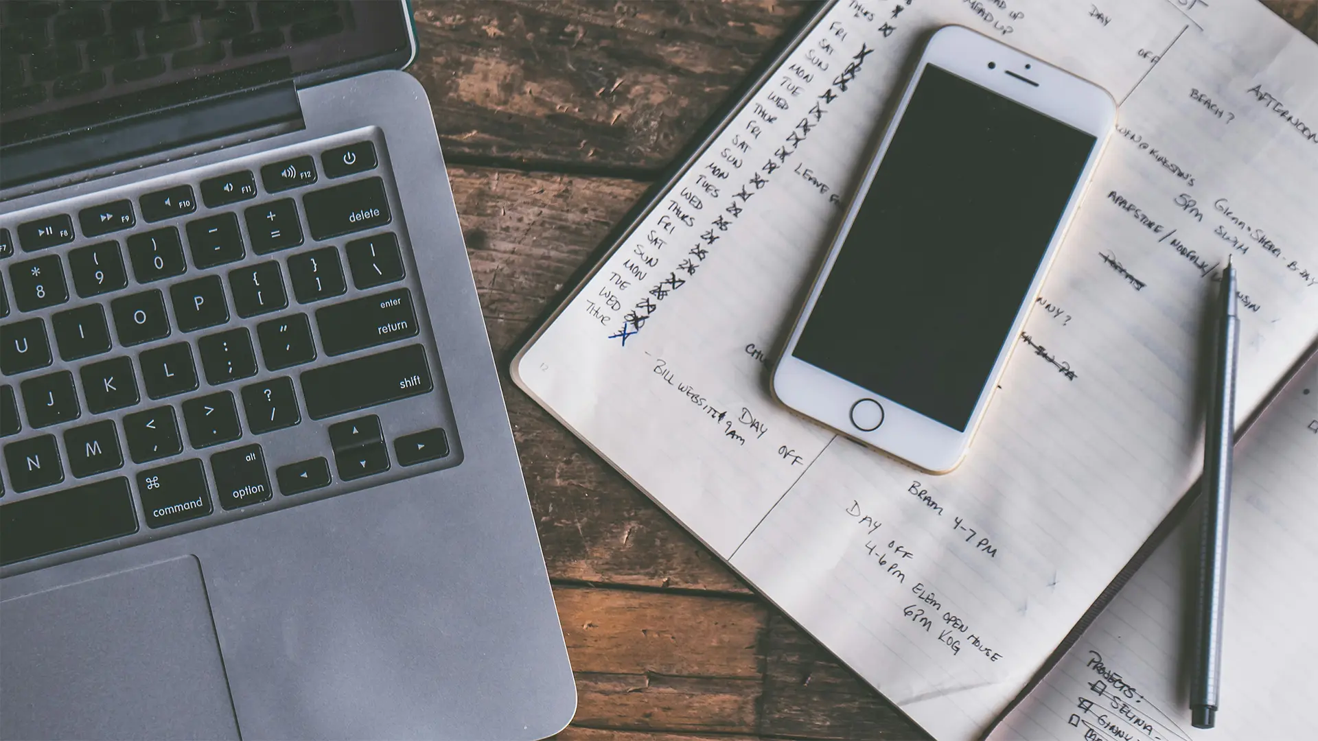 A laptop, a phone, and a to-do list on a table